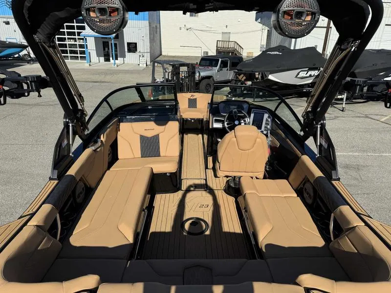 Slide: The Image of 2024 MasterCraft XT23 boat interior with tan seating and modern dashboard. - 7