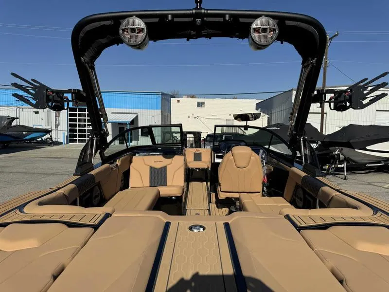 Slide: The Image of 2024 MasterCraft XT23 boat interior with tan seating and advanced audio system. - 8