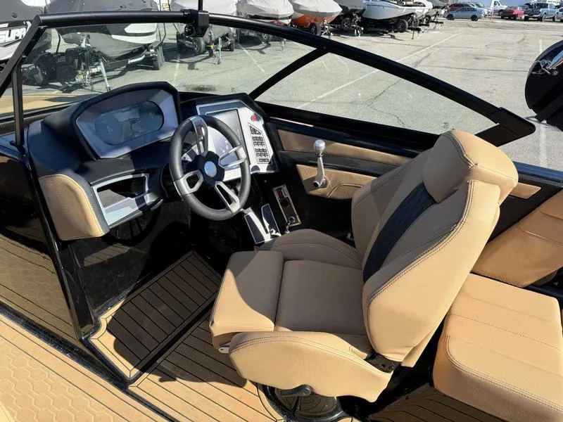 Slide: The Image of 2024 MasterCraft XT23 boat interior with modern dashboard and tan seating. - 9