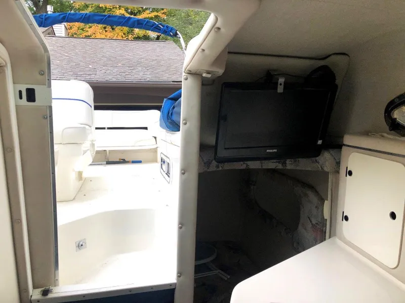 Slide: The Image of 1996 Sea Ray 250 Sundancer interior with TV and seating area. - 10