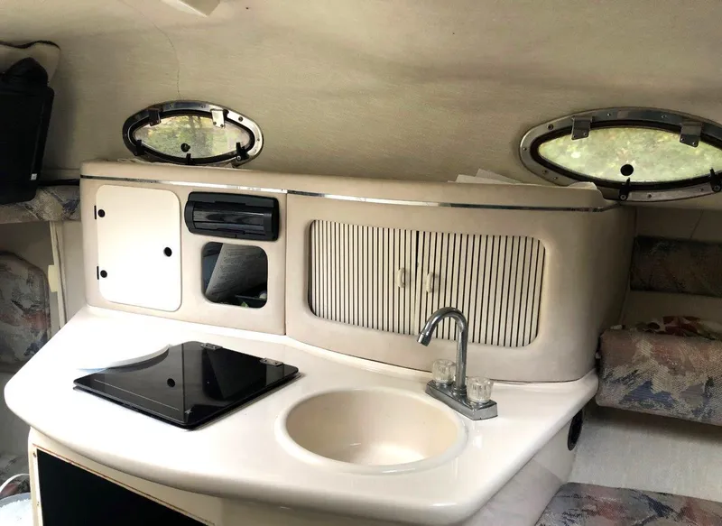 Slide: The Image of 1996 Sea Ray 250 Sundancer cabin interior with kitchenette, sink, and storage compartments. - 11
