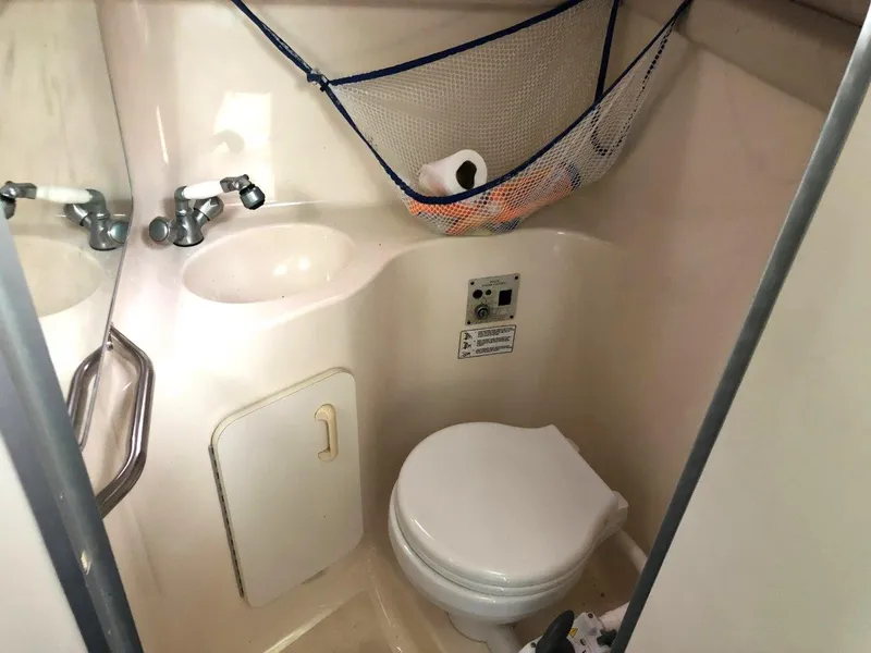 Slide: The Image of Compact bathroom in 1996 Sea Ray 250 Sundancer boat with sink and toilet. - 12