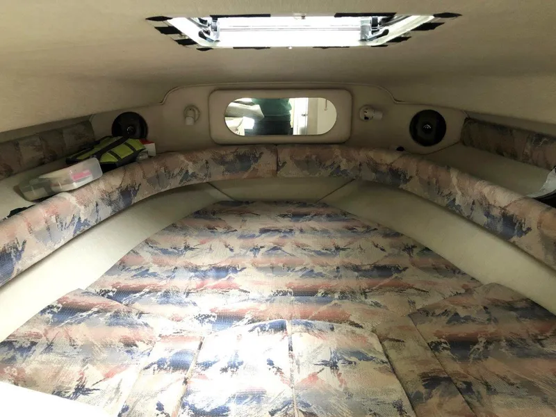 Slide: The Image of 1996 Sea Ray 250 Sundancer cabin interior with patterned upholstery and overhead hatch. - 9