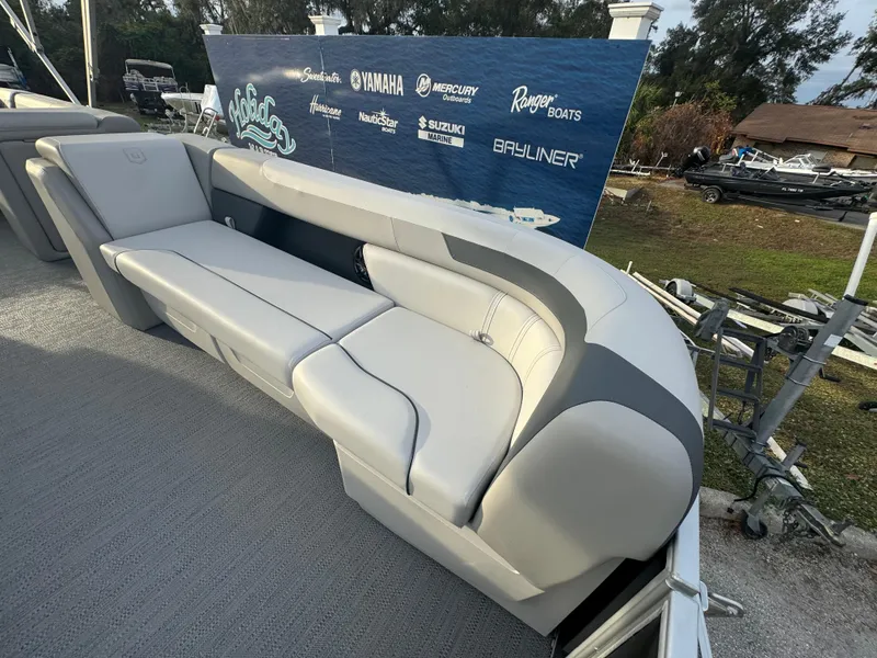 Slide: The Image of 2025 Sweetwater 2286 CSE boat with luxurious seating and branded backdrop. - 5