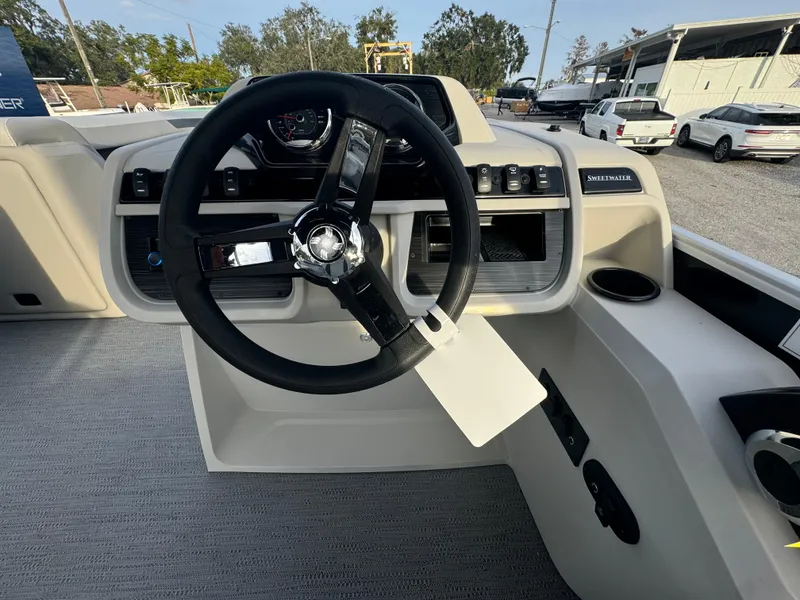 Slide: The Image of 2025 Sweetwater 2286 CSE boat steering wheel and dashboard, outdoor setting. - 8