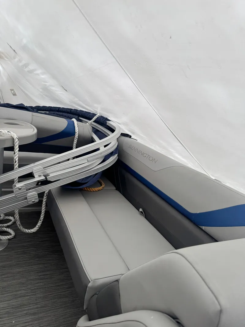 Slide: The Image of 2022 Bennington 23SXSR pontoon boat interior with gray seating and blue accents. - 9