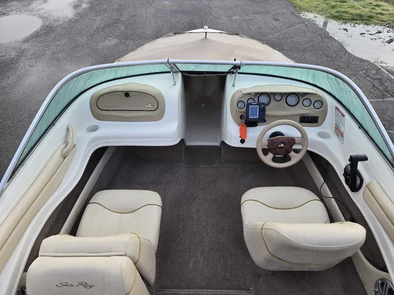 Slide: The Image of 2001 Sea Ray 180 Bow Rider interior with beige seating and dashboard controls. - 4