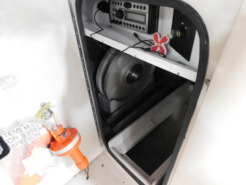 Slide: The Image of 2007 Sea Ray 260 Sundeck storage compartment with radio equipment and safety gear. - 11