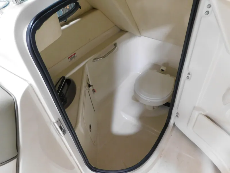 Slide: The Image of 2007 Sea Ray 260 Sundeck interior bathroom with toilet and storage space. - 8