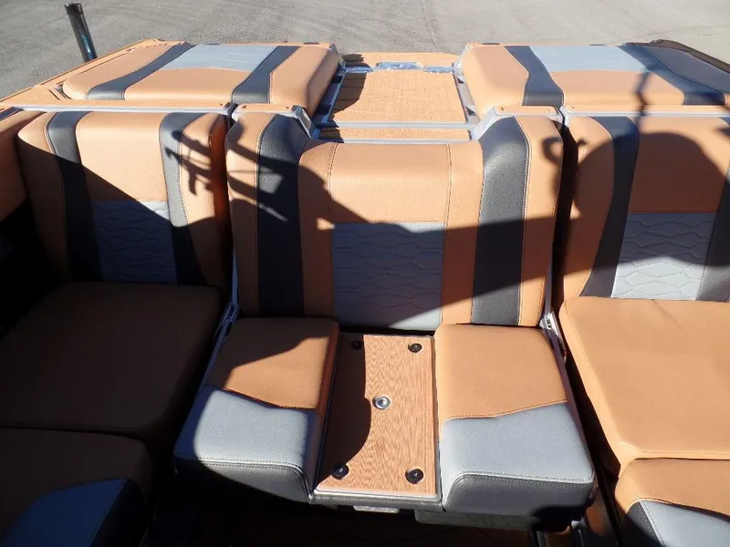 Slide: The Image of 2025 Malibu 23 MXZ boat interior with tan and gray seating. - 10