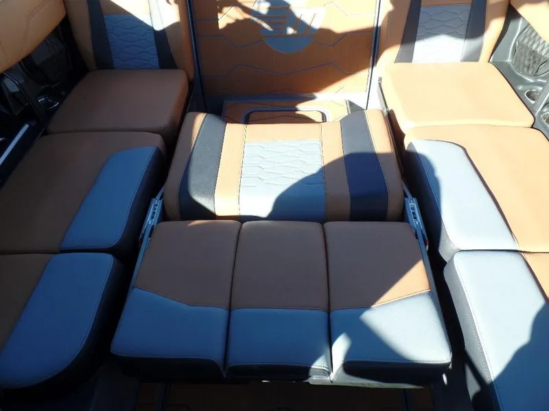 Slide: The Image of 2025 Malibu 23 MXZ boat interior with brown and gray seating arrangement. - 11