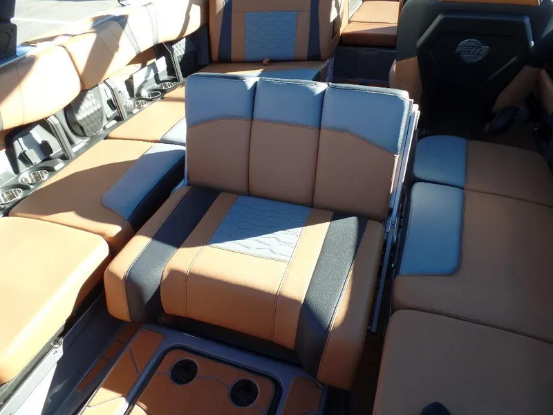 Slide: The Image of 2025 Malibu 23 MXZ boat interior with tan and gray seating. - 12
