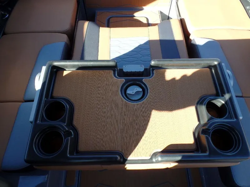 Slide: The Image of 2025 Malibu 23 MXZ interior with a stylish wooden table and cup holders. - 13
