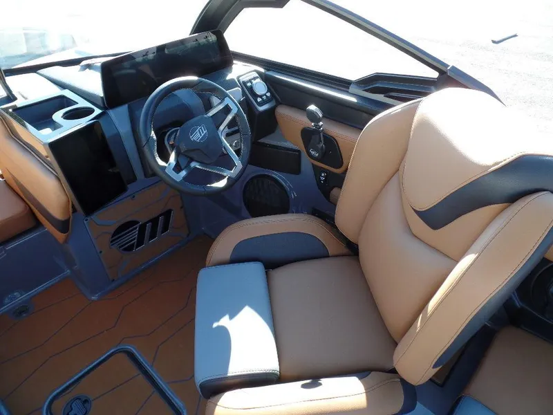 Slide: The Image of Interior of 2025 Malibu 23 MXZ boat with modern steering and tan seating. - 14