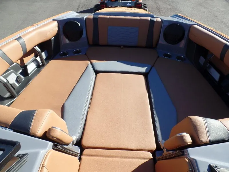 Slide: The Image of Interior seating of 2025 Malibu 23 MXZ boat, featuring tan and gray upholstery. - 15