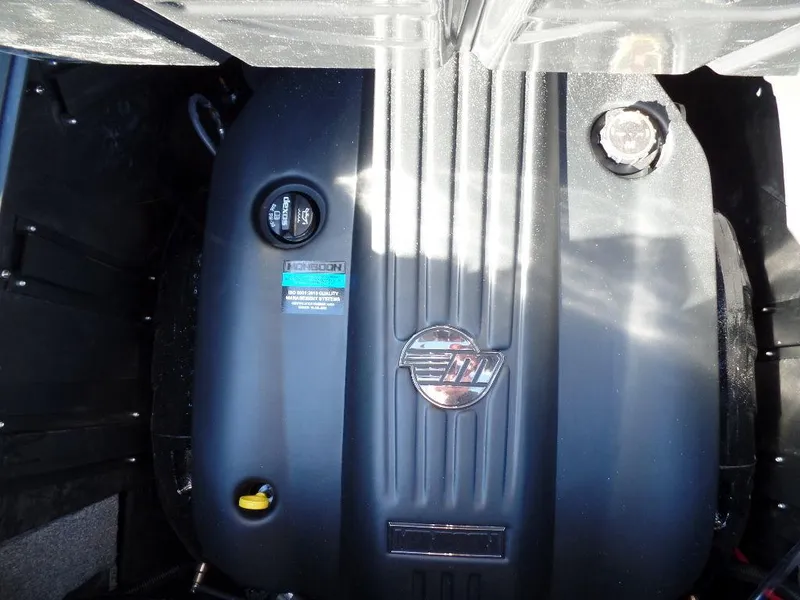 Slide: The Image of 2025 Malibu 23 MXZ engine compartment with branded cover and visible components. - 18