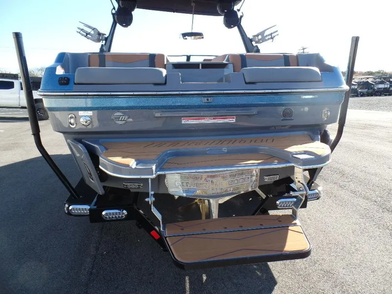 Slide: The Image of 2025 Malibu 23 MXZ boat rear view with swim platform and seating. - 3