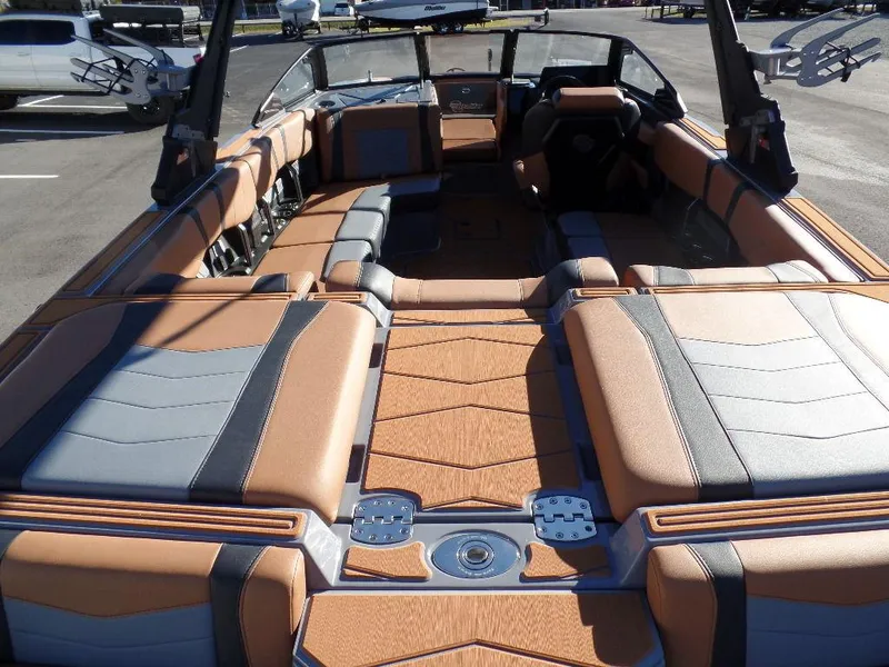 Slide: The Image of 2025 Malibu 23 MXZ boat interior with tan and gray seating, spacious layout. - 4