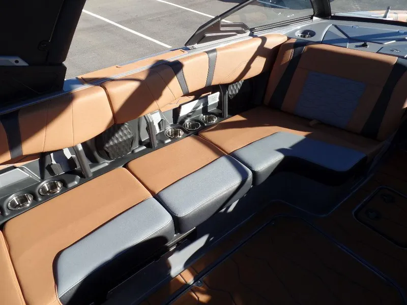 Slide: The Image of 2025 Malibu 23 MXZ boat interior with tan and gray seating, cup holders, and modern design. - 5