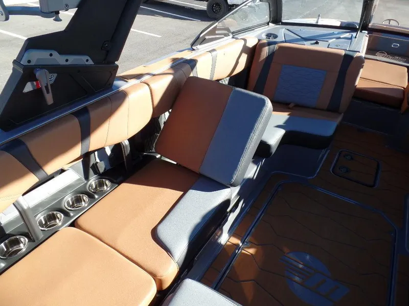 Slide: The Image of 2025 Malibu 23 MXZ interior with tan and gray seating, featuring cup holders and modern design. - 6