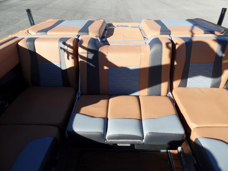 Slide: The Image of 2025 Malibu 23 MXZ boat interior with tan and gray seating. - 9