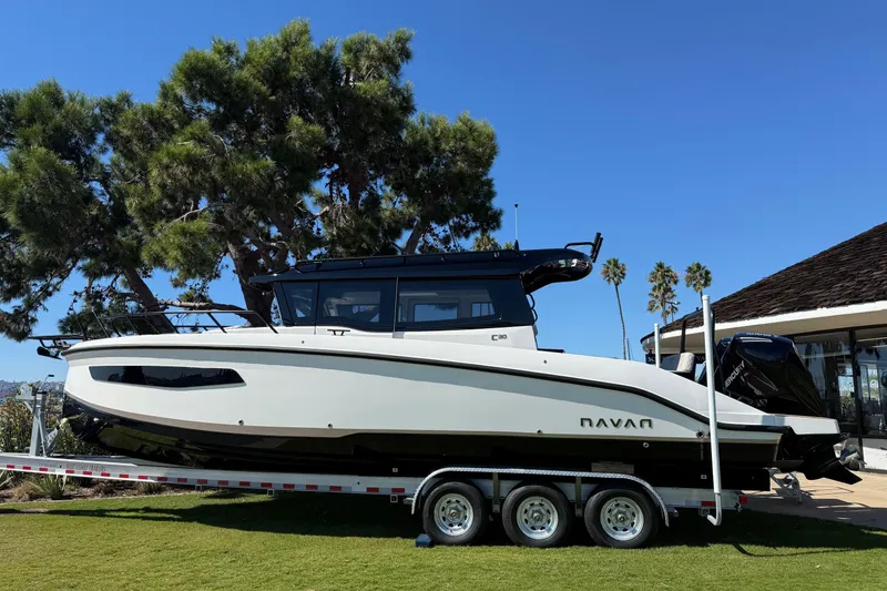 The Image of 2025 Navan C30 boat on trailer, parked on grass under clear blue sky. - 0