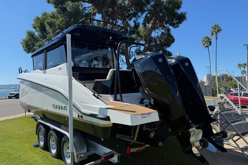 Slide: The Image of 2025 Navan C30 boat on trailer with dual outboard motors, parked near waterfront. - 2