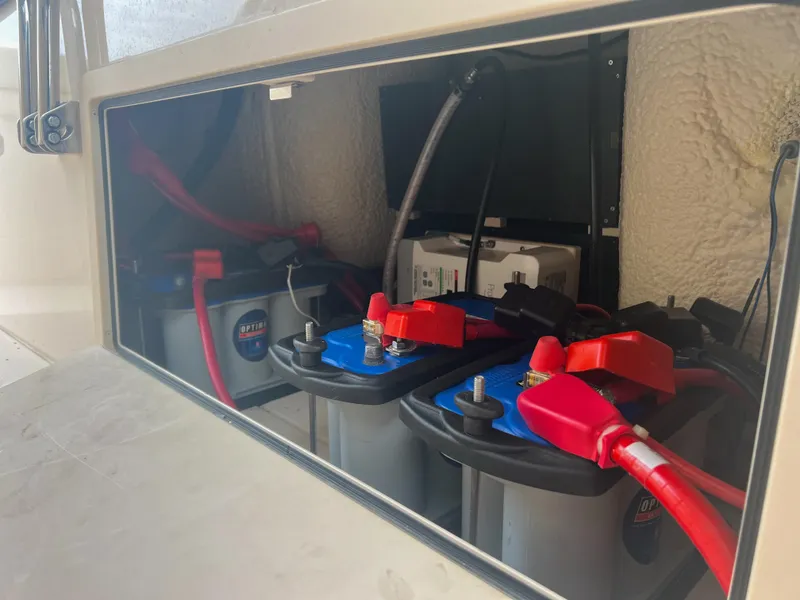 Slide: The Image of Battery compartment of 2022 Grady-White Canyon 376 boat with red and black cables. - 19