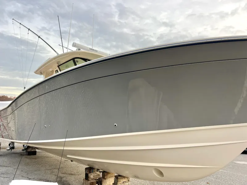Slide: The Image of 2022 Grady-White Canyon 376 boat, sleek design, docked under cloudy sky. - 2