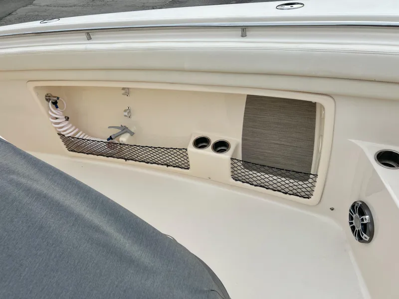 Slide: The Image of 2022 Grady-White Canyon 376 boat interior with storage net and hose. - 26