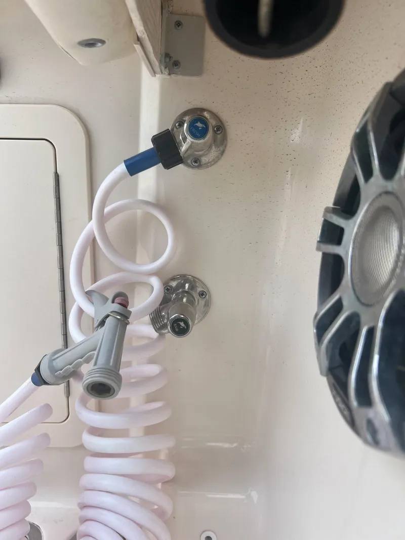 Slide: The Image of 2022 Grady-White Canyon 376 boat interior with coiled hose and speaker. - 27