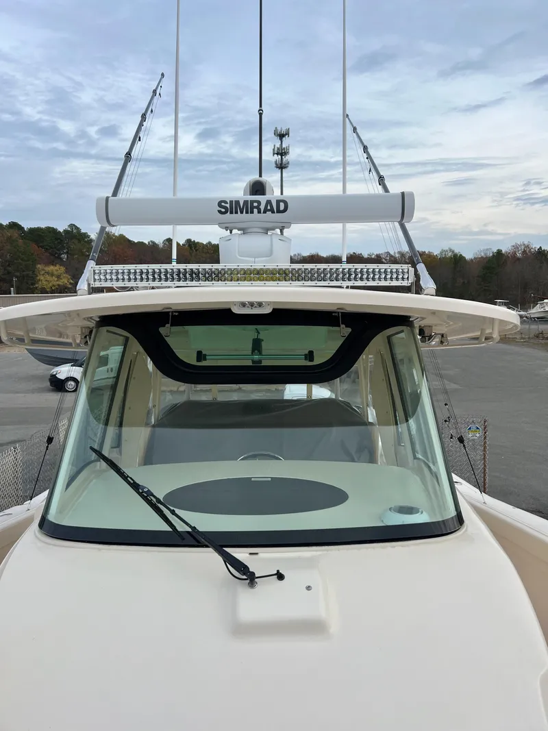 Slide: The Image of 2022 Grady-White Canyon 376 boat with Simrad radar, docked under cloudy sky. - 37