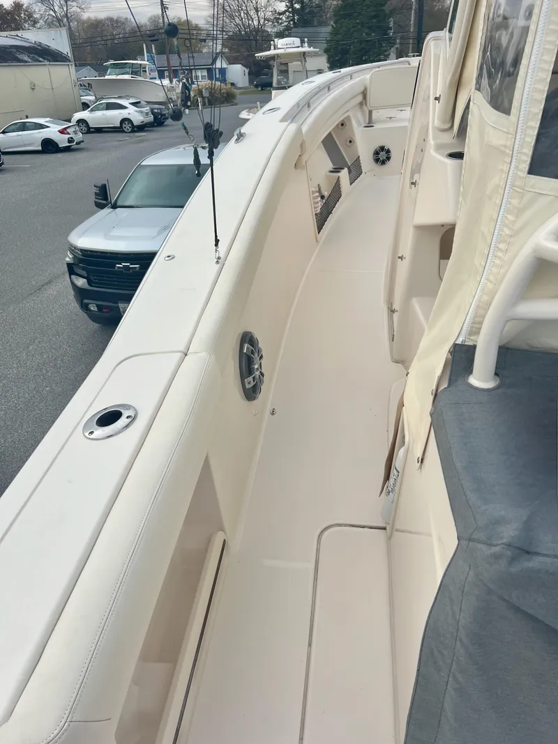 Slide: The Image of 2022 Grady-White Canyon 376 boat deck, parked in a marina with nearby vehicles. - 48