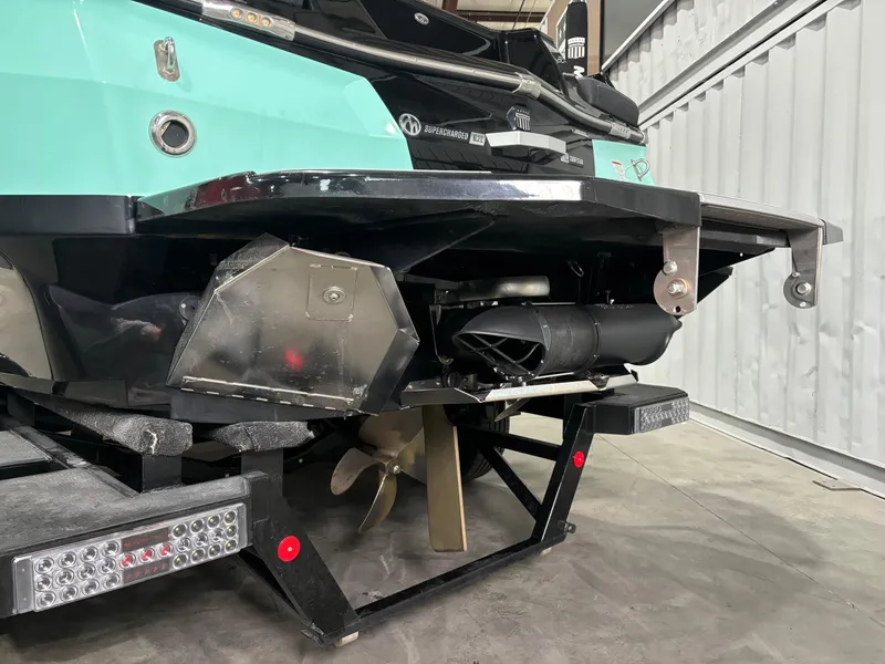 Slide: The Image of 2024 MasterCraft XStar S boat rear view, showcasing propeller and hull details in a garage setting. - 11