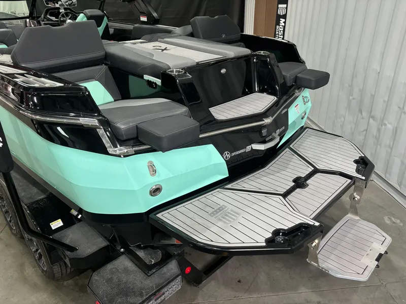 Slide: The Image of 2024 MasterCraft XStar S boat with teal and black design, featuring a swim platform. - 12