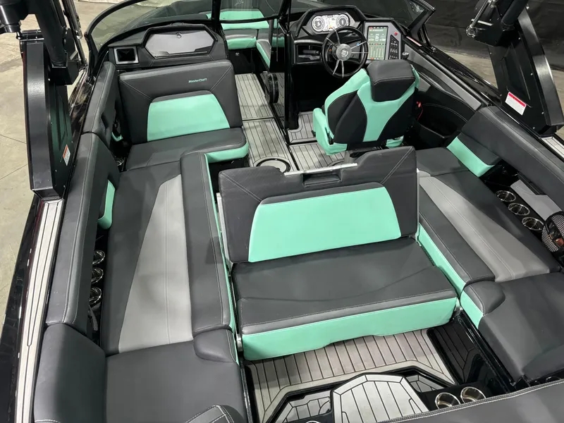 Slide: The Image of 2024 MasterCraft XStar S interior with mint and black seating, modern dashboard, and spacious layout. - 14