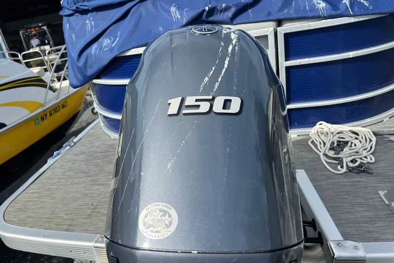Slide: The Image of 2022 Bennington 23XSSB boat with 150 horsepower outboard motor, docked with rope. - 10