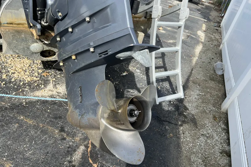 Slide: The Image of 2022 Bennington 23XSSB boat propeller and motor detail, with ladder in background. - 11