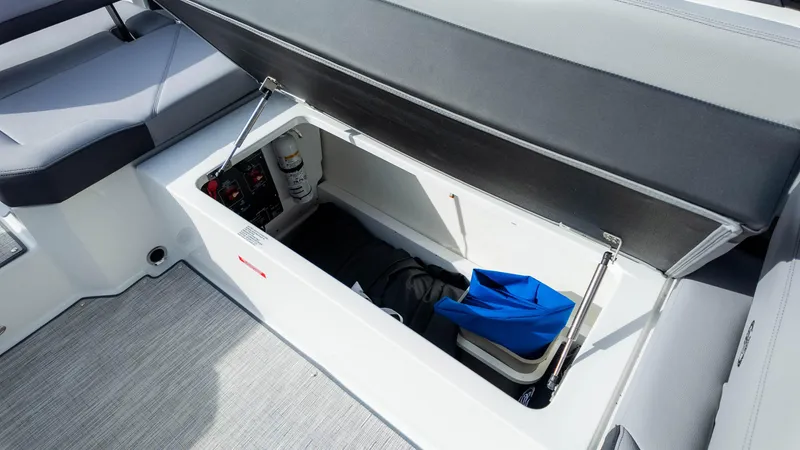 Slide: The Image of 2025 Cobalt R8 Outboard storage compartment with open lid, showcasing interior space and items. - 17