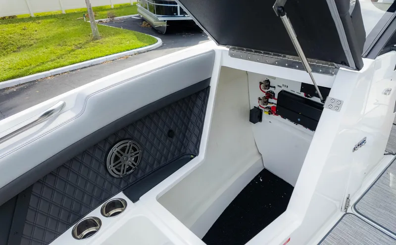 Slide: The Image of 2025 Cobalt R8 Outboard boat storage compartment with speaker and cup holders. - 22