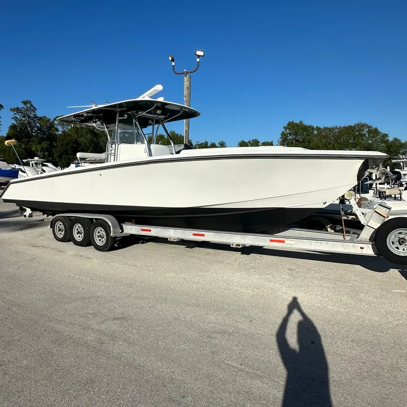Slide: The Image of 2004 Venture Open Fisherman boat on trailer under clear blue sky. - 1