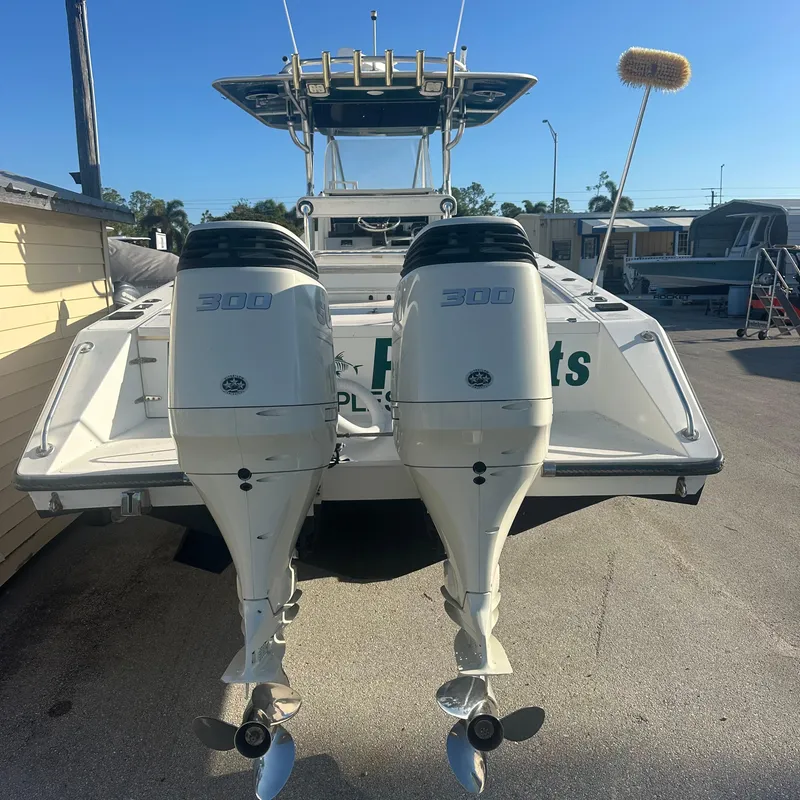 Slide: The Image of 2004 Venture Open Fisherman boat with dual 300 horsepower engines, docked outdoors. - 2