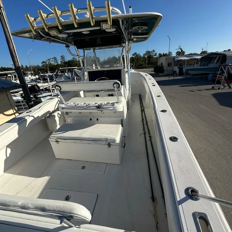 Slide: The Image of 2004 Venture Open Fisherman boat with spacious deck and seating, docked under clear skies. - 3