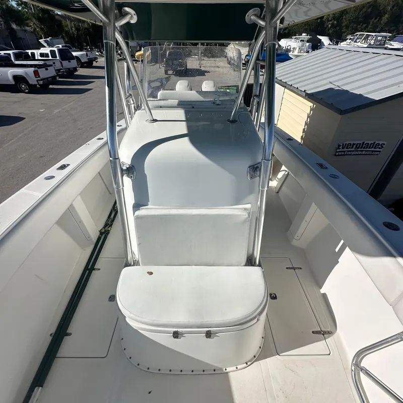 Slide: The Image of 2004 Venture Open Fisherman boat interior with seating and console, docked outdoors. - 6