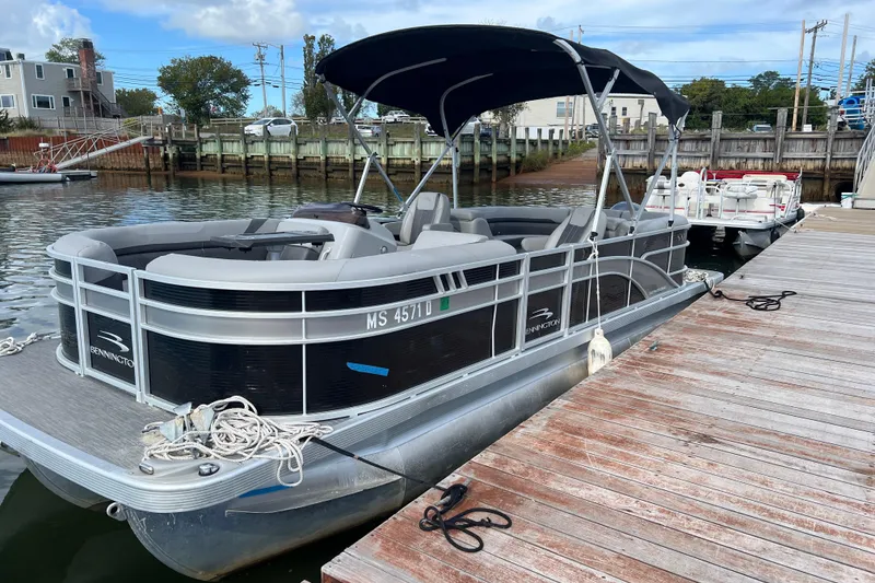 Slide: The Image of 2022 Bennington 23SXSRC pontoon boat docked at a marina. - 0