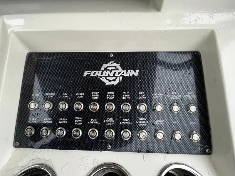 Slide: The Image of Control panel of a 2011 Fountain 38 CC Tournament Edition boat with various switches. - 20