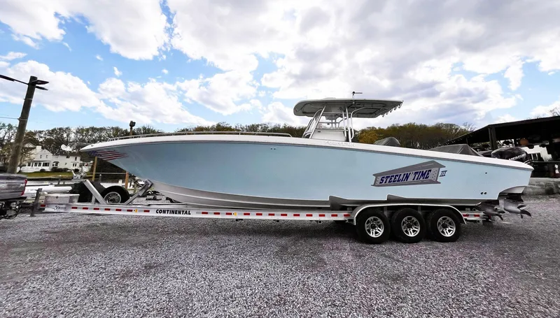 Slide: The Image of 2011 Fountain 38 CC Tournament Edition boat on trailer, under cloudy sky. - 38