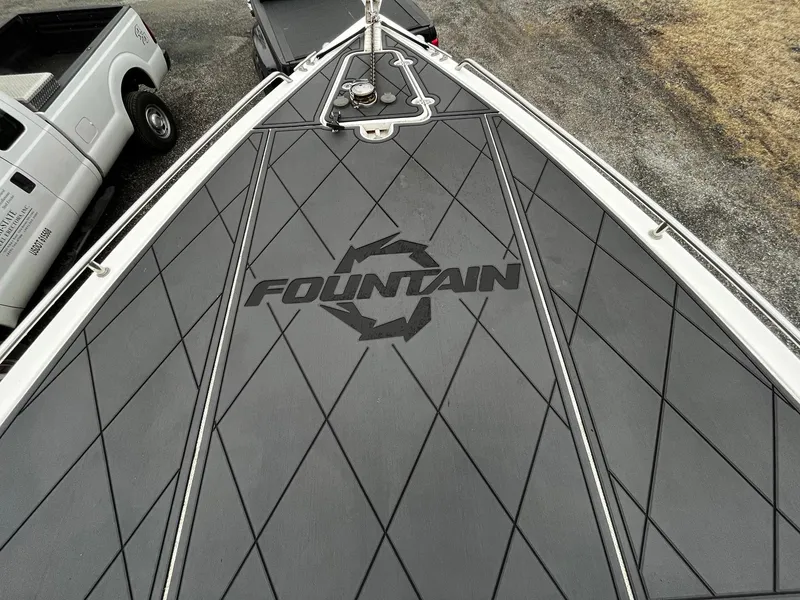 Slide: The Image of 2011 Fountain 38 CC Tournament Edition boat deck with logo, parked near a truck. - 5