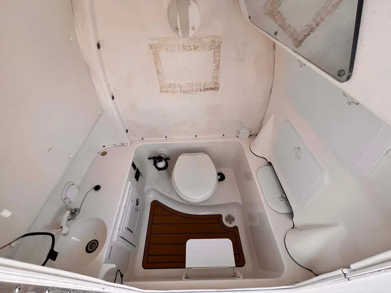 Slide: The Image of 2015 Tidewater 280 CC Adventure boat bathroom interior with toilet and sink. - 15