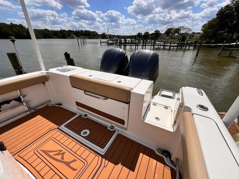 Slide: The Image of 2015 Tidewater 280 CC Adventure boat with twin engines, docked on a sunny day. - 20